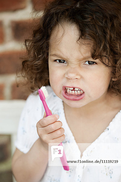Wütendes Mädchen hält Zahnbürste