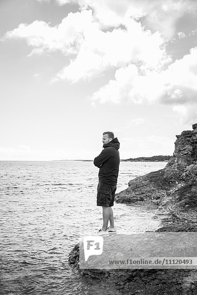 Schweden  Gotland  Älterer Mann am felsigen Meeresufer