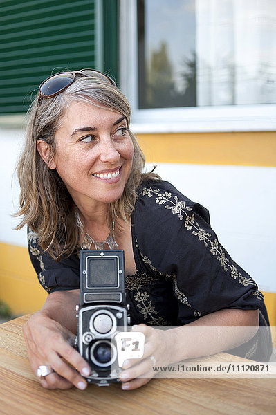 Caucasian woman holding old-fashioned camera
