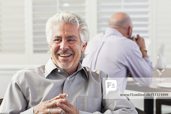Hispanic businessman laughing in cafe