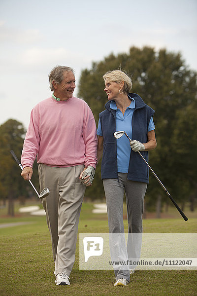 Paar geht auf Golfplatz