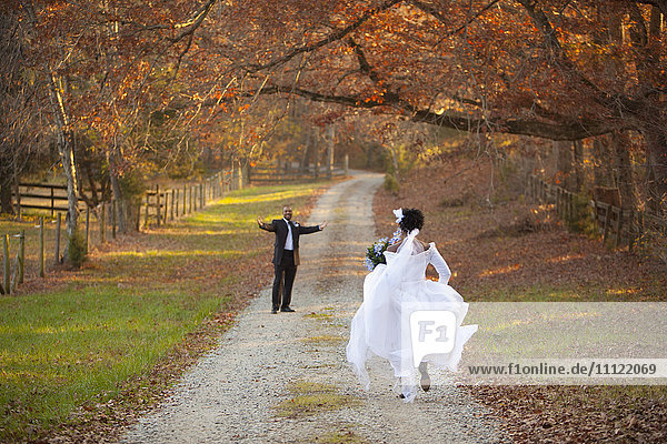 Braut und Bräutigam laufen sich auf dem Weg zu