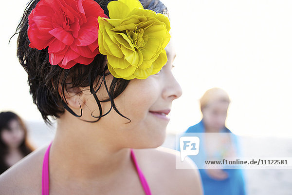 Mixed race girl on beach with flowers in her hair
