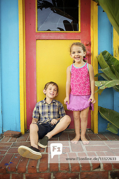 Brother and sister sitting on front stoop