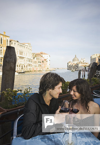 Italienisches Paar trinkt Rotwein in einem Straßencafé