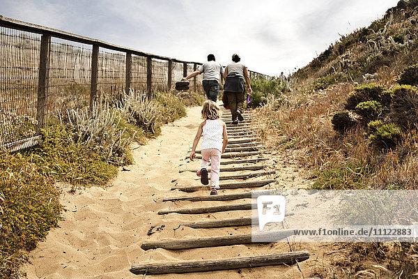 Familie geht Sandtreppe hinauf