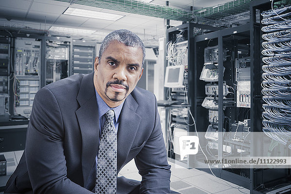 Mixed race businessman sitting in server room