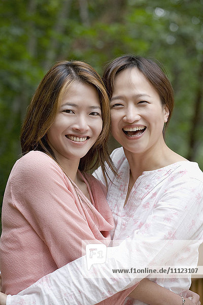 Asiatische Schwestern umarmen