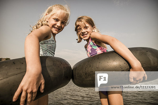 Caucasian girls with inner tubes in water