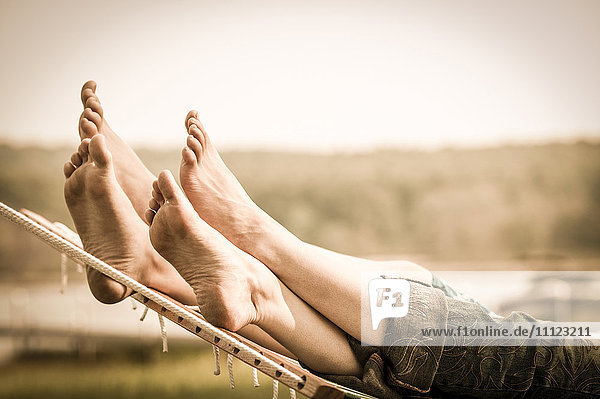 Close up of mother and child's feet in hammock