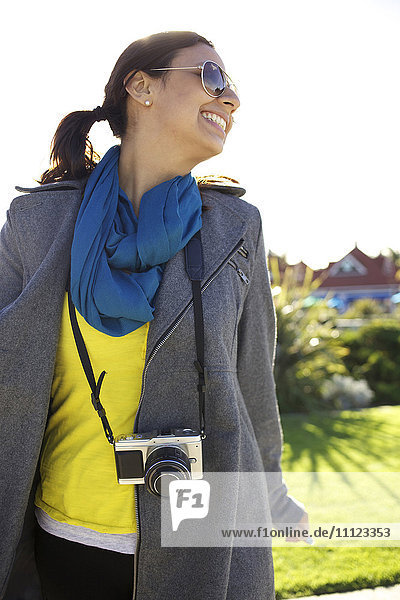 Lächelnde gemischtrassige Frau mit altmodischer Kamera
