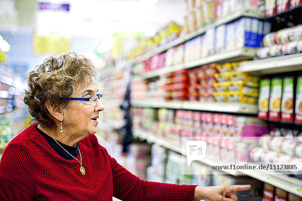 Ältere hispanische Frau beim Einkaufen in einem Lebensmittelladen