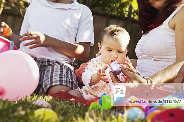 Hispanic baby playing with Easter eggs