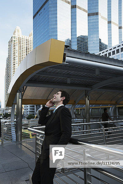 Caucasian businessman talking on cell phone outdoors