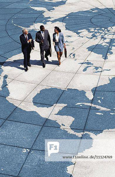 Geschäftsleute  die auf einer Weltkarte spazieren gehen
