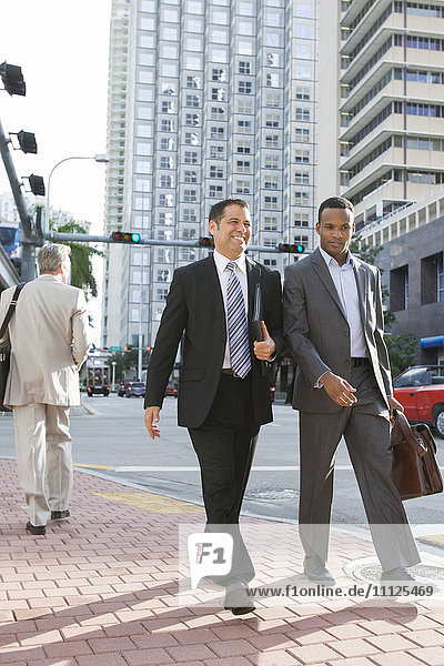 Businessmen walking together on city street