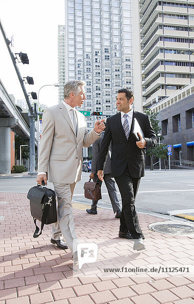 Geschäftsleute gehen zusammen auf einer Straße in der Stadt