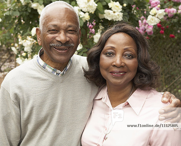 Älteres afrikanisches Paar umarmt und lächelt im Freien