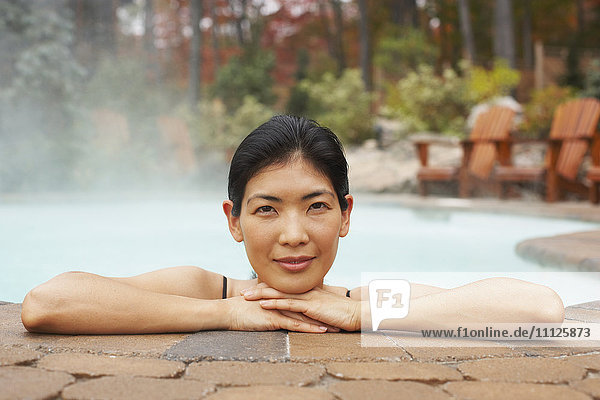 Asiatische Frau sitzt im Whirlpool
