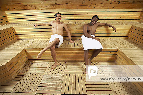 Zwei multiethnische Männer entspannen sich in der Sauna