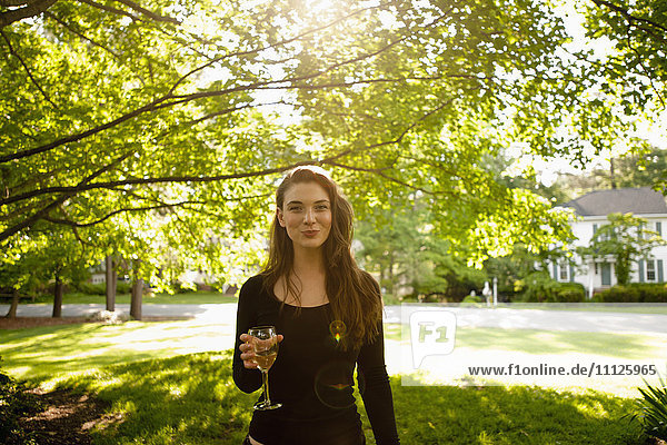 Kaukasische Frau trinkt Weißwein im Park
