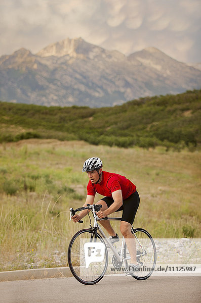 Caucasian man riding bicycle on remote road