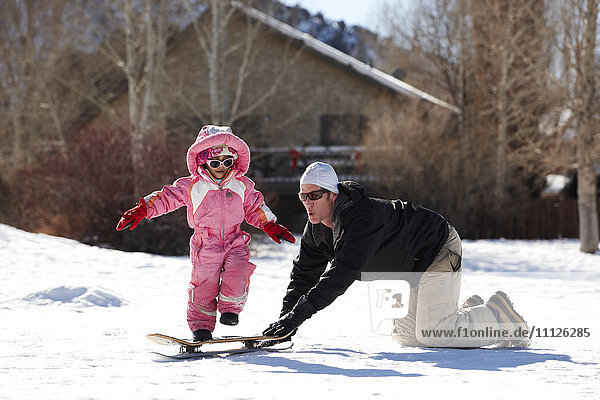 Vater und Tochter spielen im Schnee
