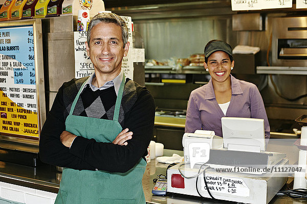 Lächelnde hispanische Kellner im Restaurant