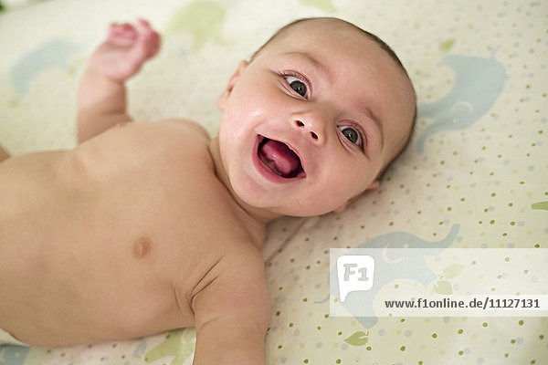 Lächelndes Baby auf einer Decke liegend
