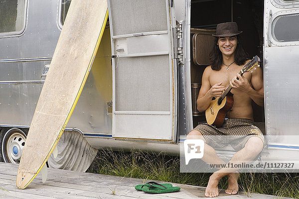 Pacific Islander man playing ukulele
