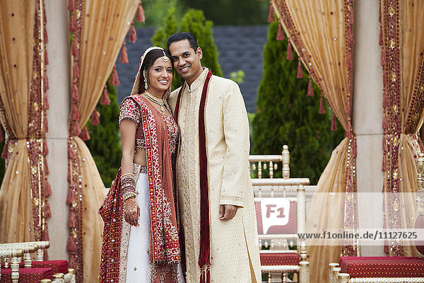 Lächelndes indisches Paar in traditioneller Hochzeitskleidung