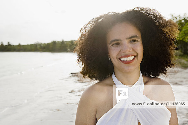 Hispanische Frau lächelnd am Meer