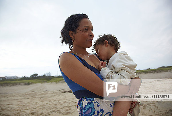 Mother holding son on beach