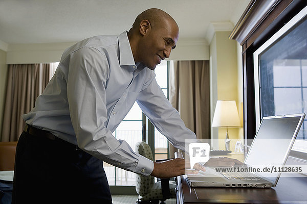 African businessman in hotel using laptop