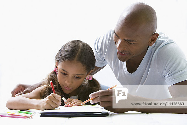 Gemischtrassiger Vater hilft Tochter bei den Hausaufgaben