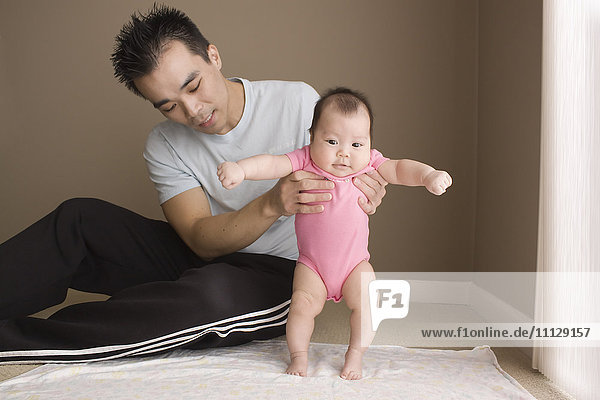 Chinese father helping daughter to learn to walk