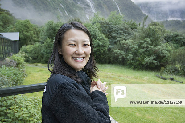 Chinese woman standing on balcony in remote area