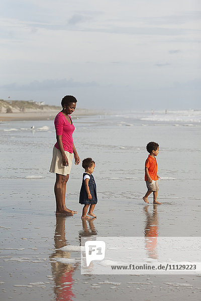Mother and children enjoying beach together