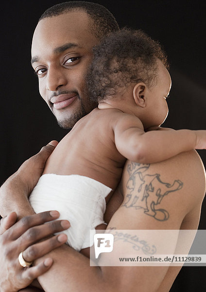 Afrikanischer Mann hält Baby