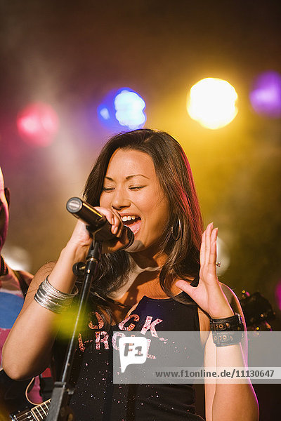 Asian woman singing onstage
