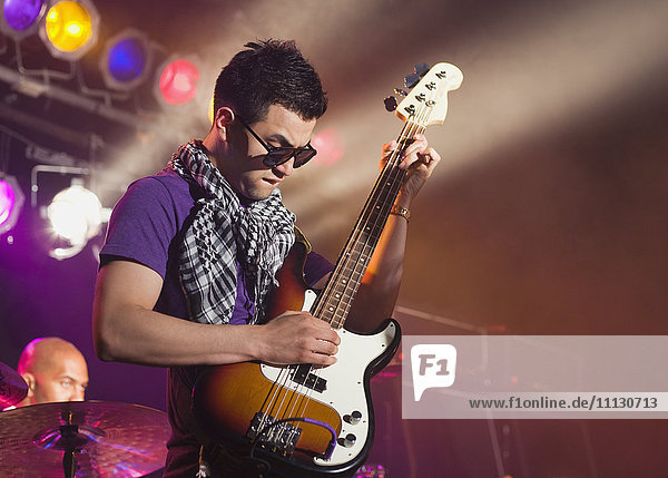 Hispanic man playing electric guitar onstage