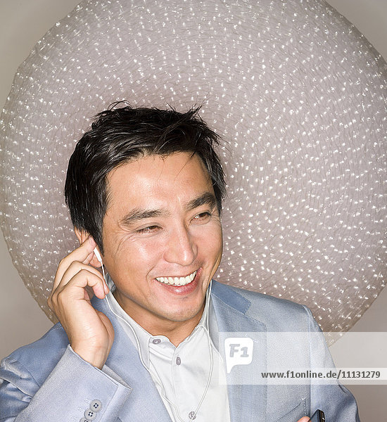 Japanese man listening to headphones