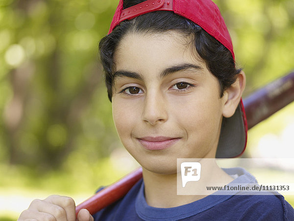 Mixed race boy holding baseball bat