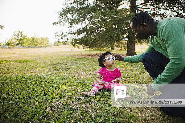 Schwarzer Vater und Tochter genießen den Park