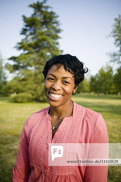 Lächelnde schwarze Frau im Park stehend