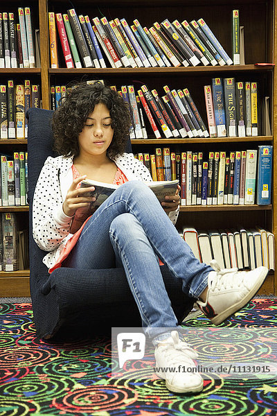 Gemischtrassiges Mädchen studiert in der Bibliothek