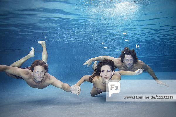 Freunde schwimmen zusammen unter Wasser