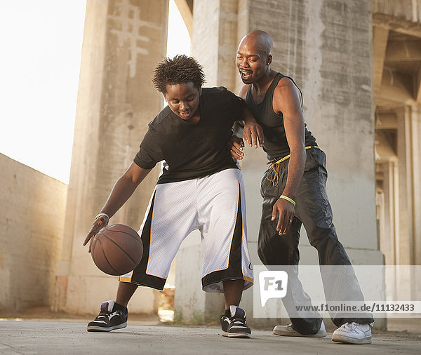 Afrikanischer Vater spielt Basketball mit seinem Sohn