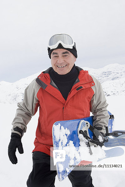 Älterer hispanischer Mann beim Snowboarden