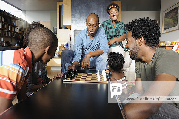 Black family watching chess game